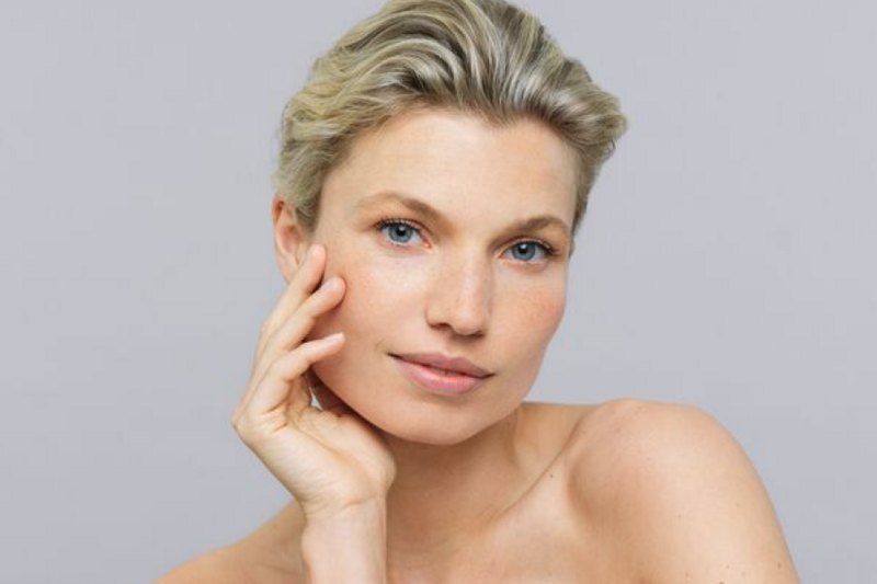 Middle-aged woman showing off her complexion after using ageLOC Future Serum on her face.